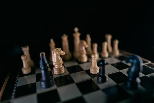 Chess pieces on a chessboard in a dark style. Selective focus