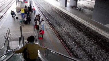 İnsanlar yürüyen merdivenle platforma