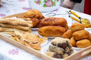 OMSK, RUSSIA - 1 Mart 2020: Halk festivalleri. Maslenitsa Rusya 'da. Sibirya 'da Maslenitsa Haftası. Karnaval. Shrovetide 'i kutlayan insanlar. İkram. Turtalar. Taze hamur işleri.
