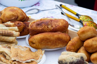 OMSK, RUSSIA - 1 Mart 2020: Halk festivalleri. Maslenitsa Rusya 'da. Sibirya 'da Maslenitsa Haftası. Karnaval. Shrovetide 'i kutlayan insanlar. İkram. Turtalar. Taze hamur işleri.