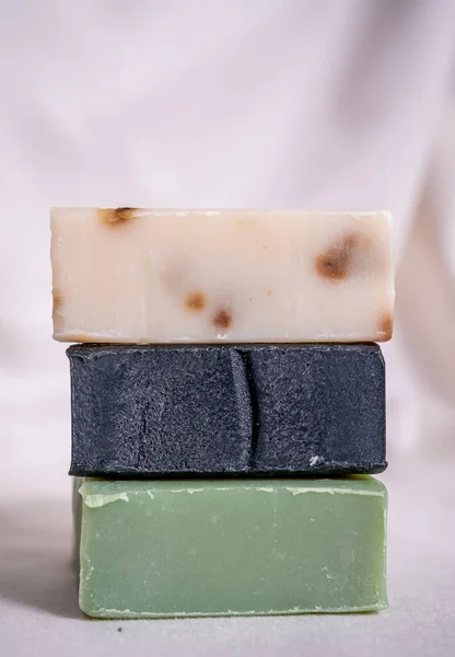 Refreshing soaps handmade from roses, aloe vera and activated carbon stacked on a white background in close up concept.