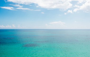Denizin farklı tonlarında olduğu güzel bir sahil ve mavi gökyüzü ile Quintana Roo Mexico 'da beyaz bulutlar.