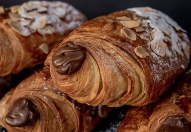 Şekerle süslenmiş siyah bir masada çikolatayla dolu nefis Fransız usulü badem çikolatalar..