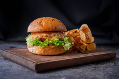 Biftekli lezzetli hamburger, brioche bun, kırmızı soğan, chipotle sosu, yanında patatesli marul....