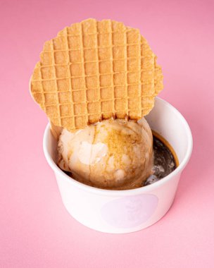 Vanilyalı dondurma, waffle kurabiyesi ve espresso ile nefis affogato, mavi ve pembe arka planlı..