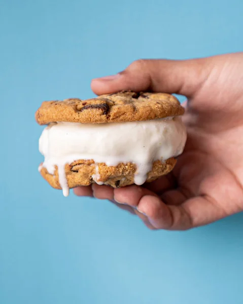 Вкусный Ванильный Сэндвич Мороженым Держащийся Руку Синем Фоне — стоковое фото
