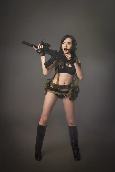 Jeune brune en camouflage avec un pistolet — Photo