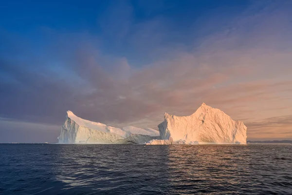 Ghiacciai galleggianti nei raggi del sole al tramonto nella notte polare — Foto Stock