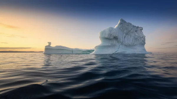 Glaciares flotantes en los rayos del sol poniente durante una noche polar —  Fotos de Stock