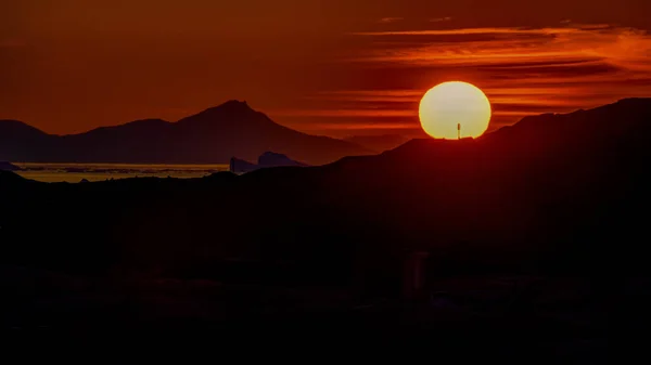 Un gran disco amarillo del sol poniente sobre el horizonte — Foto de Stock