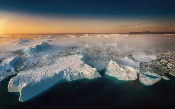 Zwevende gletsjers in de stralen van de ondergaande zon tijdens een poolnacht — Stockfoto