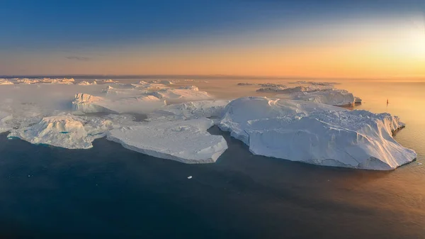 Glaciares flotantes en los rayos del sol poniente durante una noche polar —  Fotos de Stock