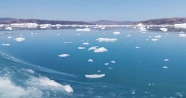 Denizde buzlar arasında yüzen kırmızı gemi