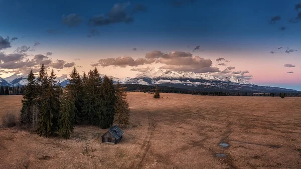 Sonnenuntergang mit einem alten Heuboden, einer Hütte auf den Wiesen unter der Westtatra — Stockfoto