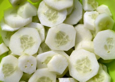 Salatalıklar masanın üzerindeki bir atrelkanın içinde dilimlenmiş.