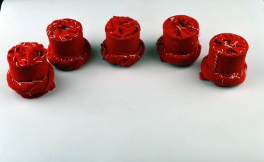 Masanın üzerinde beş dekoratif kırmızı bardak altlığı duruyor.