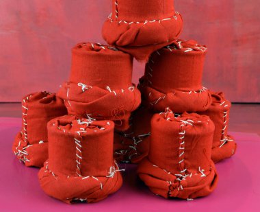 Kırmızı rengin dekoratif öğeleri masanın üzerinde bir piramit gibi duruyor.