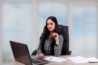 Genç işadamı, dizüstü bilgisayar kullanarak gülümseyen. 