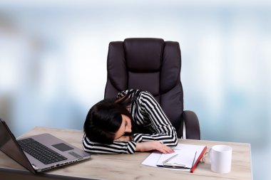 Dizüstü bilgisayarda çalışan yorgun iş kadın.