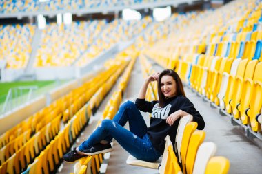 Kız Açık eğleniyor. Okul Stadı'nda oturan güzel kız. Çalışma tutun. Açık havada, yaşam biçimi