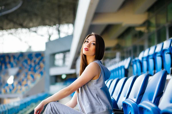 Europese jonge brunette krullend tiener model creëert een betonnen stadion trap, het dragen van zweet broek, Sneakers — Stockfoto