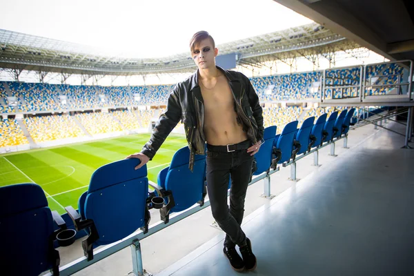 Retrato de un joven con chaqueta de cuero contra el estadio — Foto de Stock