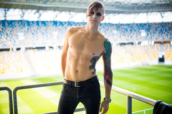 Joven se para en el estadio, torm desnudo, tatuajes, posando — Foto de Stock