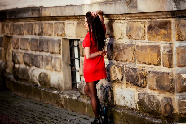 Mujer en el vestido largo rojo mirando hacia atrás — Foto de Stock