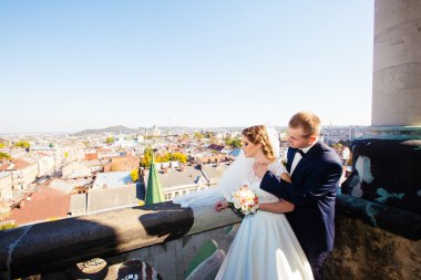 Şehir Manzaralı Balkonda duran güzel düğün çift yeni evliler