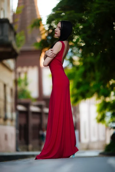 Retrato de uma bela jovem com cabelo escuro, vestindo um lindo vestido vermelho ao ar livre — Fotografia de Stock