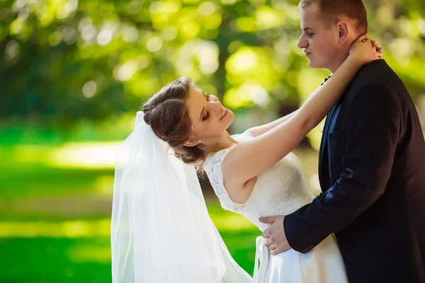 Sposo abbraccia sposa sullo sfondo del centro storico della città — Foto Stock