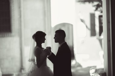 Fotoğraf çekim düğün. Gelin ve damat şehirde yürüyüş. Kucaklayan ve birbirine bakarak evli çift. Buket tutarak. Açık, tam vücut