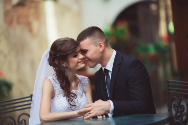 kafede açık havada günbatımı üzerinde oturan Düğün çifti