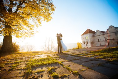 Güzel genç gelin ve yakışıklı damat eski konak günbatımında açık havada dans