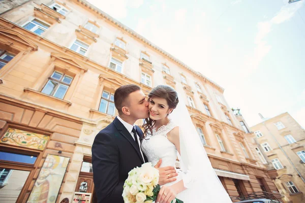 Gyönyörű esküvői pár élvezi a napsütéses nap az óvárosban az építészet — Stock Fotó