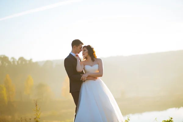 Noiva feliz e bela noiva morena bonita em um vestido branco, abraçar sob o arco — Fotografia de Stock
