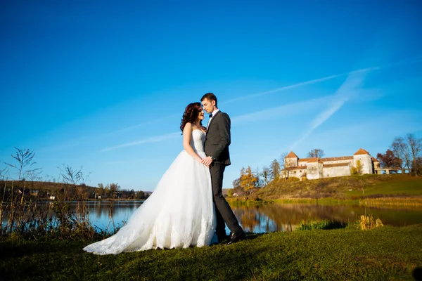 Beautiful sensual bride groom holds the bride by the old castle — Stock Photo, Image