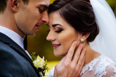 Güzel mutlu genç gelin güneşli Park yakışıklı damat öpüşme