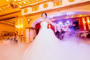 Restoranda düğün dansı. Güzel esmer gelin damat bir koyu takım elbise ve beyaz bir elbise.