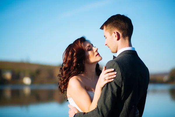 Belle jeune mariée heureuse embrassant beau marié dans le parc ensoleillé — Photo