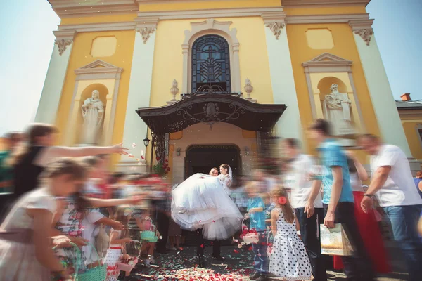 Bride and groom posing in front of the church — ストック写真