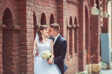 Muhteşem bir düğün çifti, eski şehirde mimari ile güneşli bir günün tadını çıkarıyor.