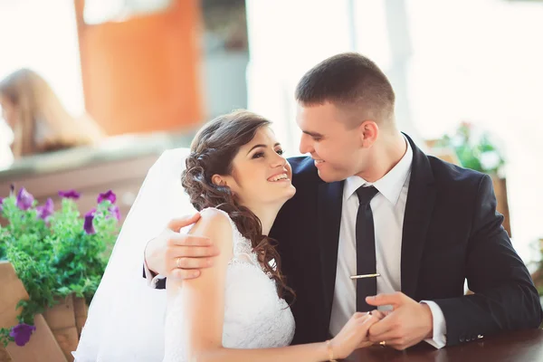 Bruid en bruidegom op een outdoor cafe, kijken elkaar enamor — Stockfoto