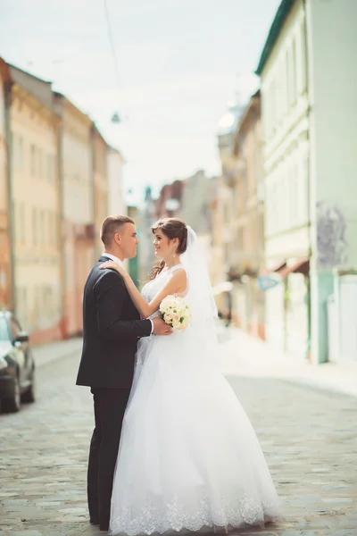 Gelukkige bruid en bruidegom dansen op een straat — Stockfoto