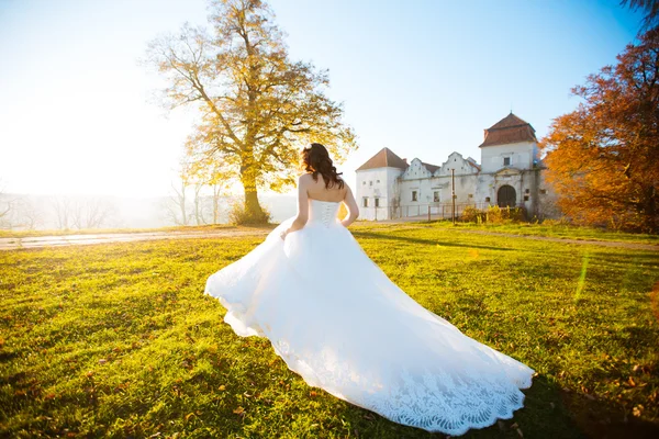 Fiatal menyasszony élvezi a nap séta a virágos réten — Stock Fotó