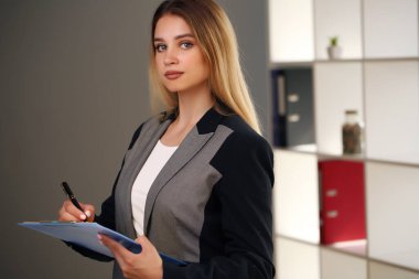 Sarışın ofiste notlar alıyor. İş kadını.