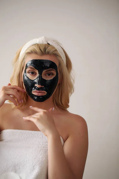 얼굴에 청명 한 검은 마스크를 쓴 아름다운 금발 여성. — 스톡 사진