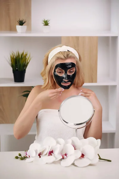 Happy girl mengenakan masker wajah Wanita muda yang mengalami hari spa perawatan kulit - hari perawatan kecantikan dan konsep produk kosmetologi — Stok Foto