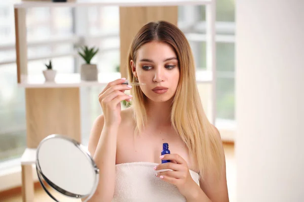 Concept de soins de la peau, portrait de femme heureuse appliquant de l'huile cosmétique sur le visage. Images De Stock Libres De Droits