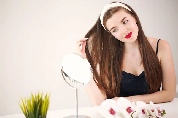 Mulher bonita aplicando óleo de coco em seu cabelo em casa — Fotografia de Stock